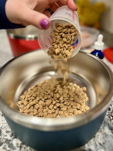 pouring dry dog food into bowl