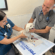 Dr. James St. Clair, veterinarian at Meriden Animal Hospital, examining a small dog with a vet tech during a checkup.